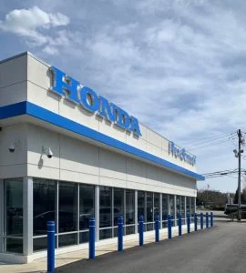 Car dealership with white EIFS exterior walls and blue accent columns in East Brunswick, NJ by CMB Stucco