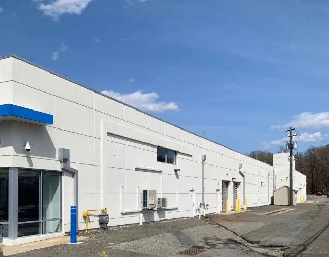 Commercial building with white EIFS exterior walls and blue accent trim in East Brunswick, NJ by CMB Stucco