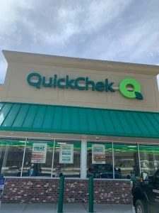 Convenience store with stucco exterior facade and green awning in East Brunswick, NJ by CMB Stucco