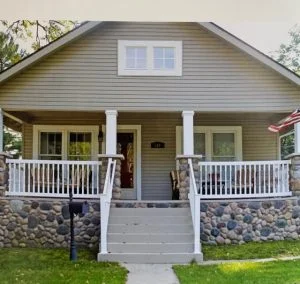 Residential home with river stone veneer porch foundation and white railings in East Brunswick, NJ by CMB Stucco